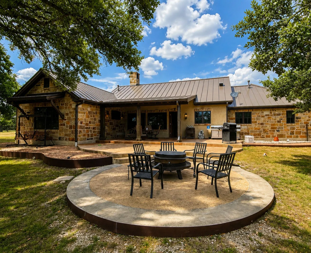 Stone lodge with a fire pit patio under the live oaks